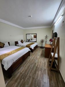 Habitación de hotel con 2 camas y escritorio en Phương Thảo Hotel en Hanói