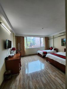 een hotelkamer met 2 bedden en een televisie bij Phương Thảo Hotel in Hanoi