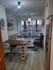 un soggiorno con divano e tavolo di Acogedor Departamento Central con Piscina, Estacionamiento Privado y Más a La Serena