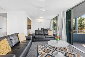 a living room with a couch and a table at Beachside on Brakes in Gold Coast