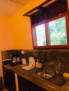 a kitchen counter with a sink and a window at MALLI'S VILLA in Koggala