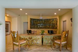une salle à manger avec une table, des chaises et un tableau dans l'établissement Quinta Real Huatulco, à Santa Cruz Huatulco