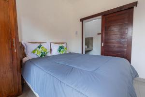 um quarto com uma cama azul e uma porta de madeira em Bali DD homestay seminyak em Seminyak