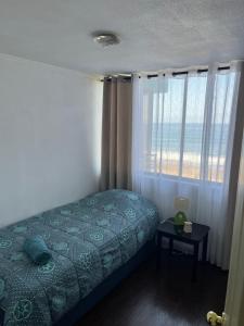 1 dormitorio con cama y ventana grande en Aguamarina,Apart, en Iquique