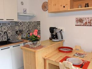 eine Küche mit einer Theke und einem Tisch mit Blumen in der Unterkunft Studio Saint-Jean-d'Aulps, 1 pièce, 4 personnes - FR-1-573-116 in Saint-Jean-dʼAulps
