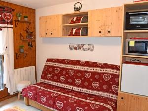 Kleines Zimmer mit einem Bett und einer Mikrowelle. in der Unterkunft Studio Saint-Jean-d'Aulps, 1 pièce, 4 personnes - FR-1-573-116 in Saint-Jean-dʼAulps