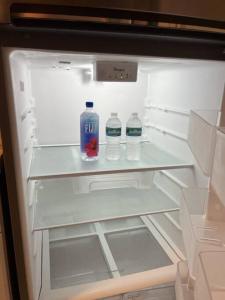 an open refrigerator with bottles of water in it at Luxury Suite by Tampa Convention Center & Hospital in Tampa