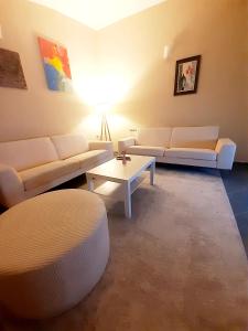 a living room with white couches and a table at 2 bedroom Centre apartment in Podgorica