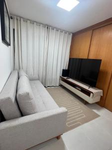 a living room with a couch and a flat screen tv at Salvador Prime - Caminho das Árvores in Salvador