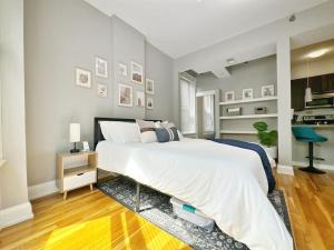 a bedroom with a large white bed with a rug at Boho Studio Loft Meets Luxury in OTR Cincinnati! in Cincinnati