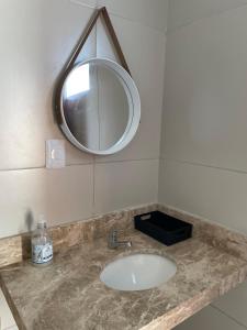 a bathroom sink with a mirror on a counter at Sunset Chalés in São Miguel do Gostoso