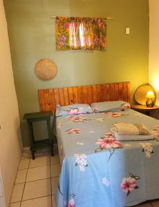 - une chambre avec un lit bleu orné de fleurs dans l'établissement Namoasuites, à Maceió