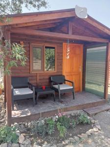 eine kleine Hütte mit 2 Stühlen und einer Veranda in der Unterkunft Doğal,Kaliteli,Huzurlu,Avantajli in Döşeme