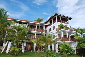 a building with palm trees in front of it at Marina Bentota in Bentota