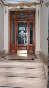 una gran puerta de madera en un edificio con escaleras en Alquiler de habitación, con baño privado. en Buenos Aires