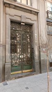 a door on a building with a tree in front of it at Alquiler de habitación, con baño privado. in Buenos Aires