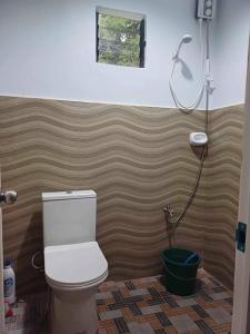 een badkamer met een toilet en een douche bij Camp Asgard by Camiguin Viajeros House Rentals in Catarman