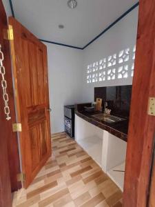 a kitchen with a counter and a sink and a door at Camp Asgard by Camiguin Viajeros House Rentals in Catarman