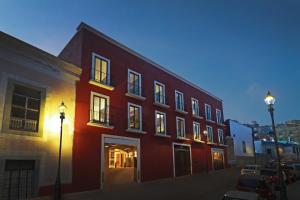 un bâtiment rouge dans une rue avec deux feux de rue dans l'établissement Hotel Indigo Guanajuato, an IHG Hotel, à Guanajuato