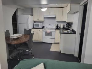 a kitchen with white appliances and a wooden table at Private basement apartment in Saskatoon