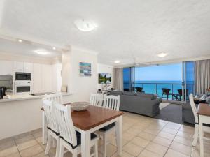 eine Küche und ein Wohnzimmer mit einem Tisch und Stühlen in der Unterkunft Peninsula 21b in Gold Coast