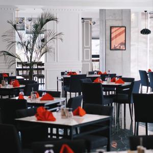 un comedor con mesas y sillas con servilletas rojas en Hevea Hotel & Resort, en Ángeles