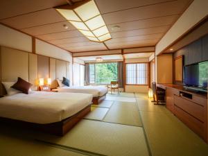 蔵王温泉にある蔵王四季のホテルのベッド2台、薄型テレビが備わるホテルルームです。