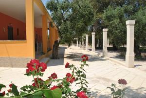 una calle con flores rojas delante de un edificio en Tenuta La Spezia, en Carpignano Salentino