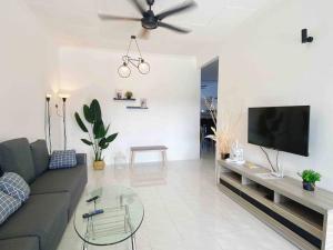 a living room with a couch and a flat screen tv at Diamond Bay Homestay in Teluk Intan