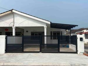 uma casa com um portão em frente em Diamond Bay Homestay em Teluk Intan