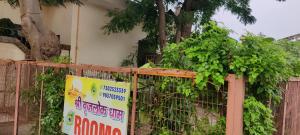 a fence with a sign in front of a building at Brijlok Dham homestay in Mathura