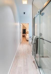 a hallway leading to a bathroom with a glass door at BEST of Downtown Indy Luxury Oasis 8BD Entire Home in Indianapolis