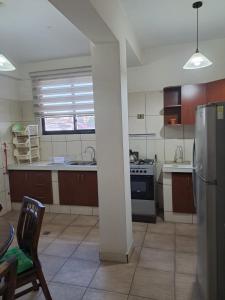a kitchen with a stainless steel refrigerator and a table at Departamento para 3 personas in Cochabamba