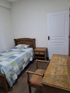 a bedroom with a bed and a wooden table at Departamento para 3 personas in Cochabamba