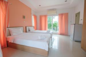a large bedroom with two beds and a television at รีสอร์ท เรือนชมดาว in Ban Nong Ban Kao