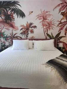 um quarto com uma grande cama branca e papel de parede tropical em Miami Oasis: Private House, Backyard and BBQ em Miami