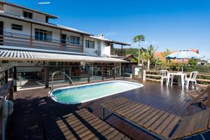 een zwembad op een terras naast een huis bij Hospedagem Engenho Fortaleza in Florianópolis