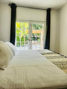 uma cama grande num quarto com uma janela grande em Miami Oasis: Private House, Backyard and BBQ em Miami