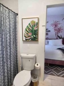 uma casa de banho com um WC branco e uma cama em Miami Oasis: Private House, Backyard and BBQ em Miami