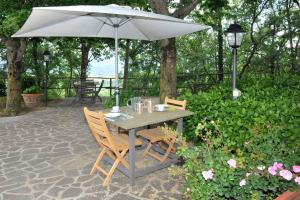 a table and chairs with an umbrella on a patio at Holiday home in Vicchio - Toskana 27442 in Vicchio +12 photos
