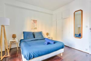 a bedroom with a blue bed and a mirror at Appartement Quartier Saint Michel in Paris