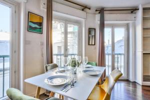 a dining room with a white table and chairs at Appartement Quartier Saint Michel in Paris