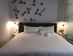 Bedspread Hostel في بانكوك: غرفة نوم مع سرير مع ملاءات بيضاء وملاحظات سوداء
