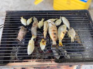 a bunch of fish cooking on a grill at Romny cozy bay Resort in Koh Rong Sanloem