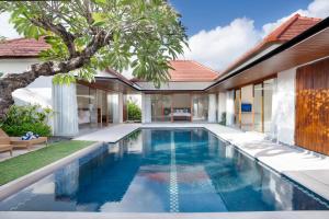 an infinity pool in the backyard of a villa at Fenosa Seminyak Villas by Nagisa Bali in Seminyak