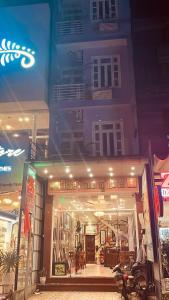 Hue thuong hotel في هوى: متجر أمام مبنى في الليل