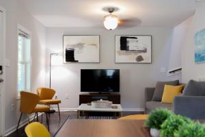 een woonkamer met een bank en een tv bij Eagle's Aerie Stunning 3bdrm Destination Home in Durham