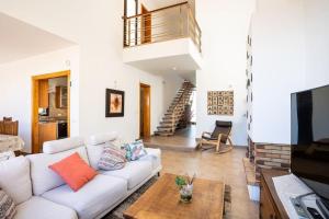 uma sala de estar com um sofá branco e uma mesa em Villa de la Huerta con piscina privada y barbacoa em Güímar