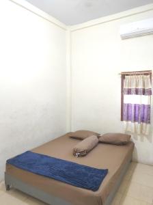 Topoyo的住宿－Wisma Tiga Putra Belawa 1，白色客房的一张床位,设有窗户