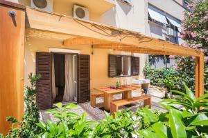 un patio esterno con tavolo in legno e panca di Apartment Dora a Spalato (Split)